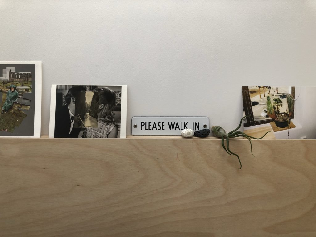 Postcards, rocks and an airplant arranged on a picture rail