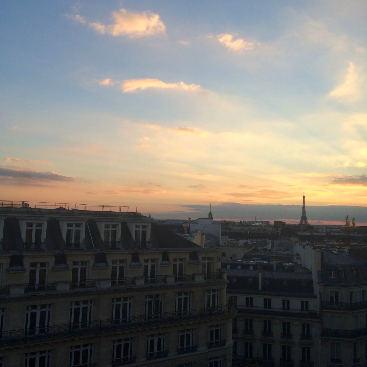 Parisian rooftops at sunset with the Eiffel Tower in the background