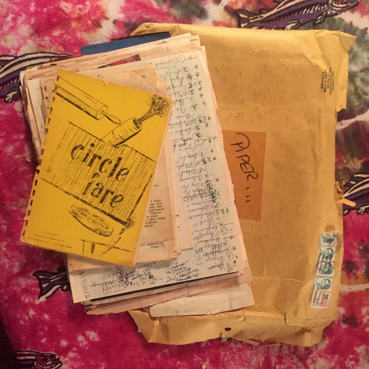 Stack of hand-written recipes on a tie dyed bedspread