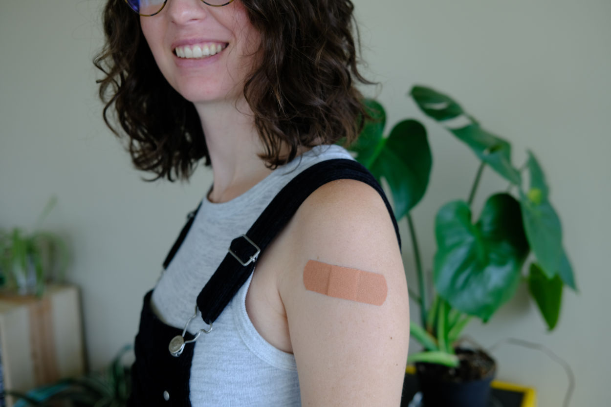 Woman with Bandaid on her arm from Covid vaccine