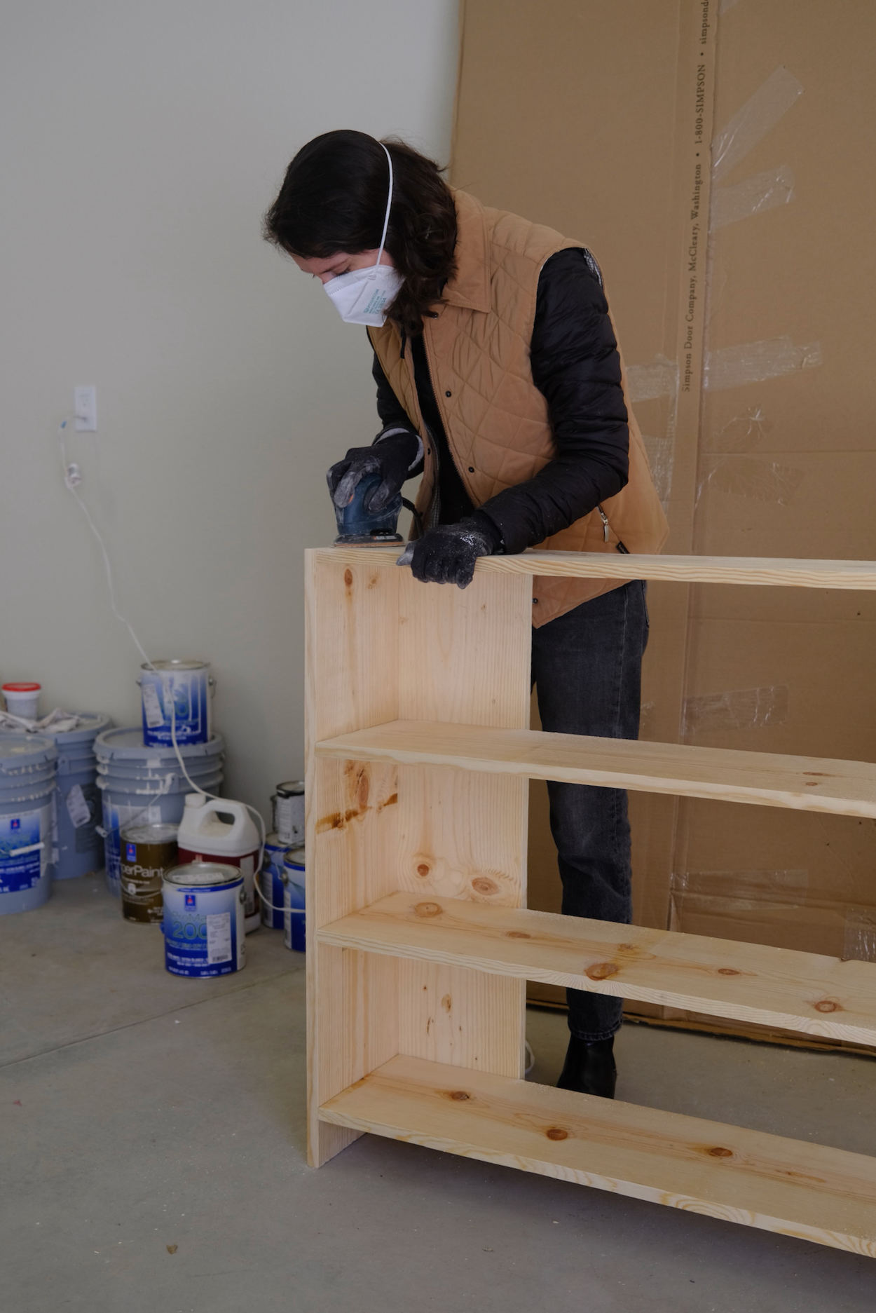 Woman sanding a set of Rietveld crate shelves