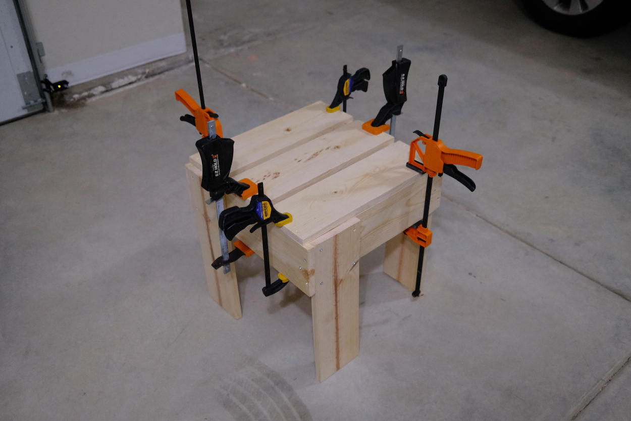 Seat slats clamped to the base of a Rietveld crate stool