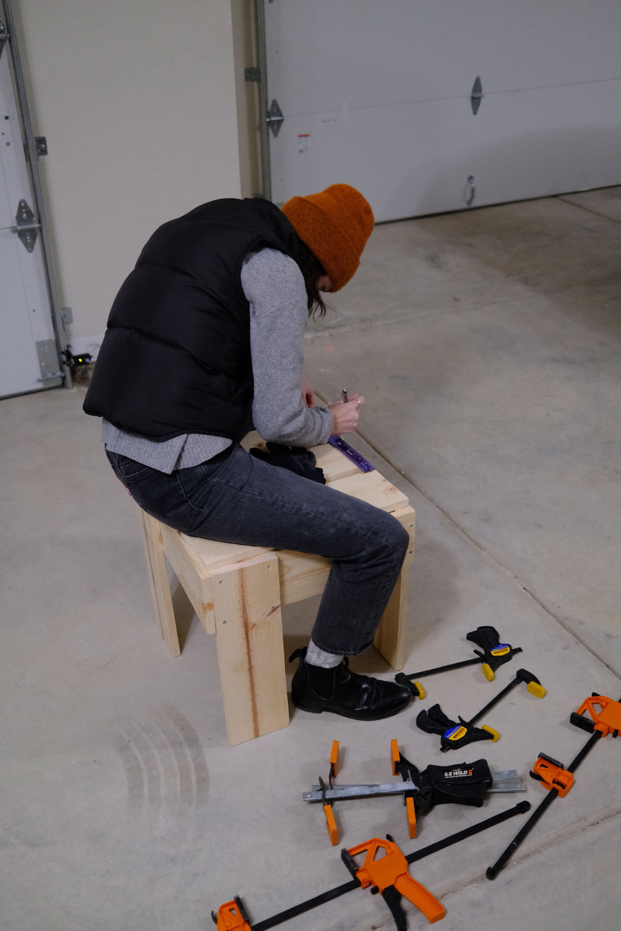 Woman marking pilot holes on the seat of a Rietveld crate stool