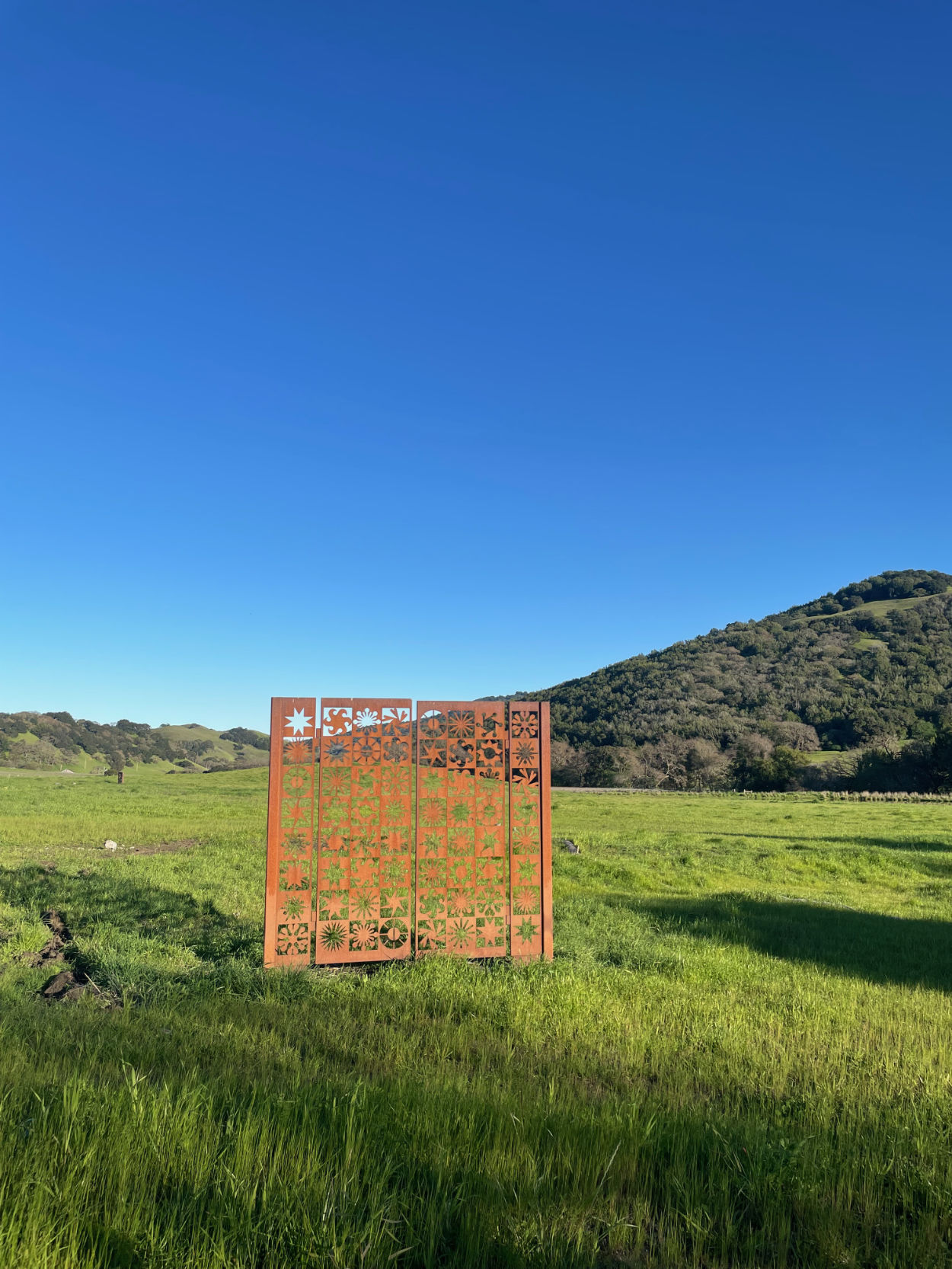 Lucia Eames’s sculptural gate at the Eames Ranch with green hills and blue skies